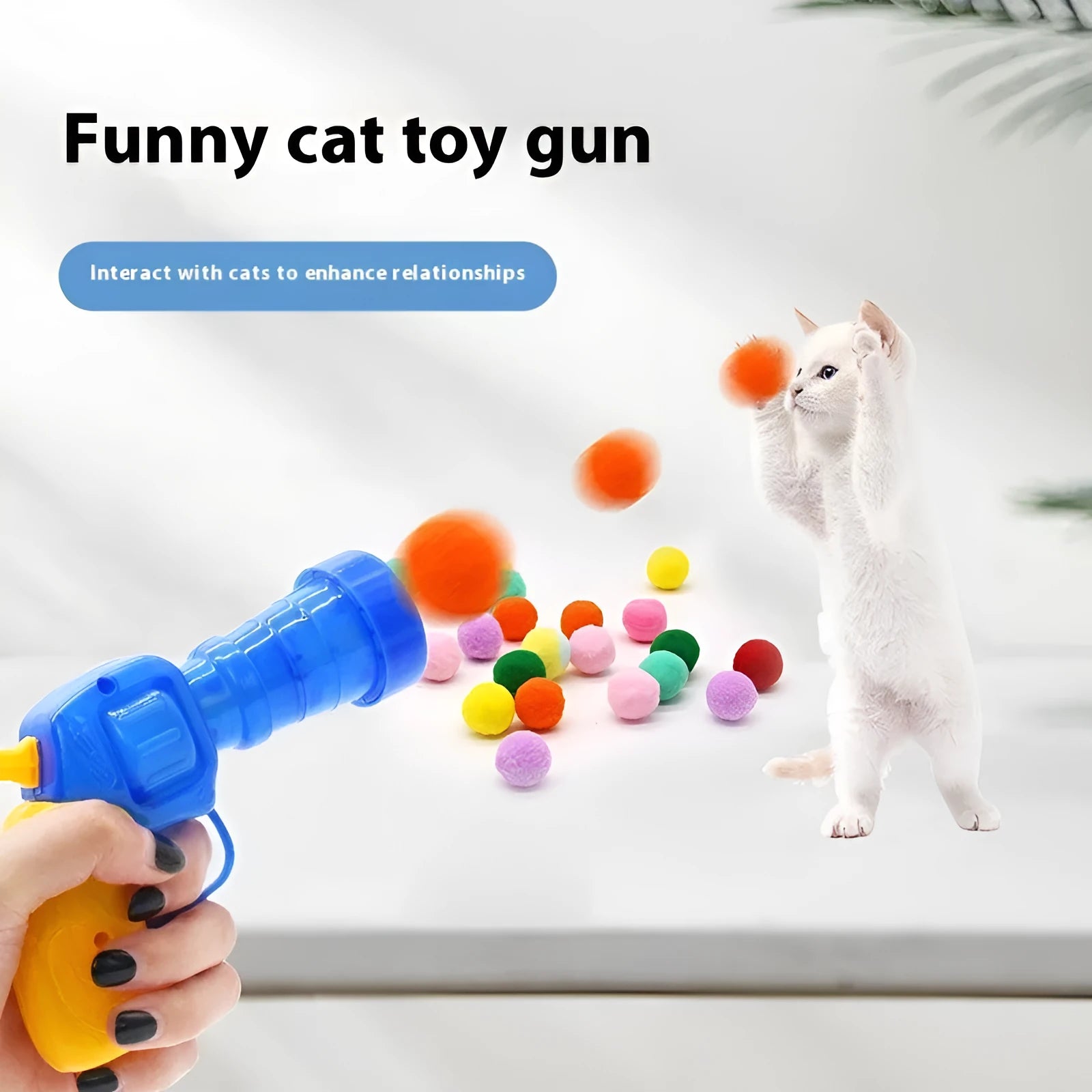 Pet toy launcher gun and soft plush balls for interactive play with cats and dogs.