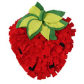 Red and green strawberry-shaped snuffle mat for dogs and cats on a floor.