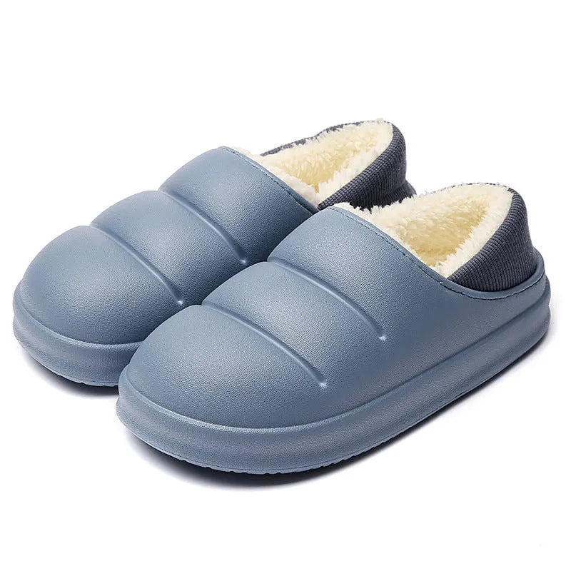 Green waterproof EVA garden slippers with plush lining and a non-slip sole, shown on a wooden deck.