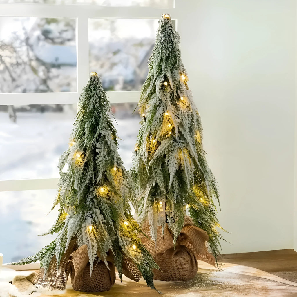 Small 24-inch artificial Christmas tree with battery-powered lights and PE simulated snow spray on branches