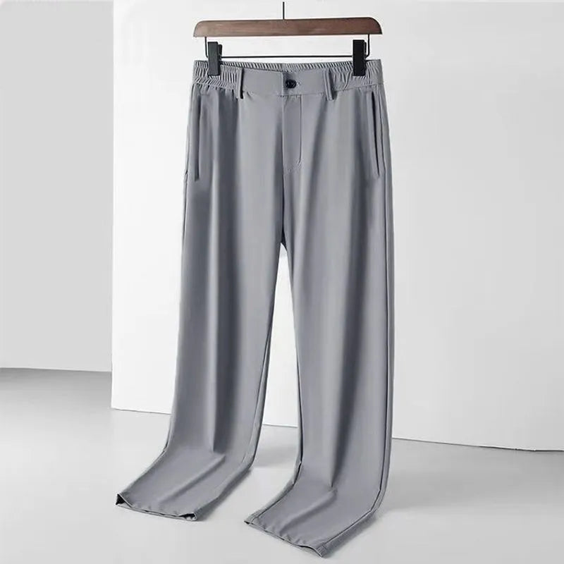 Men's black ice silk leisure trousers with elastic waist and straight leg design laid flat