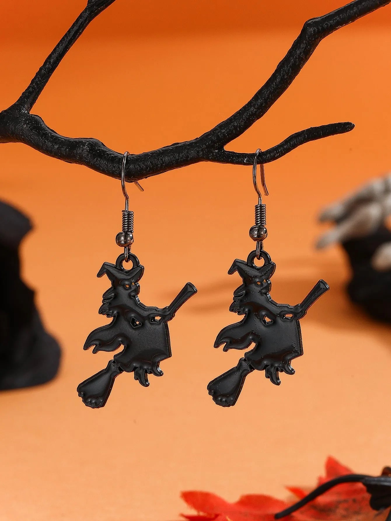 Set of six Halloween earrings with bat, cat, pumpkin head, skeleton, spider, and witch motifs on a dark background