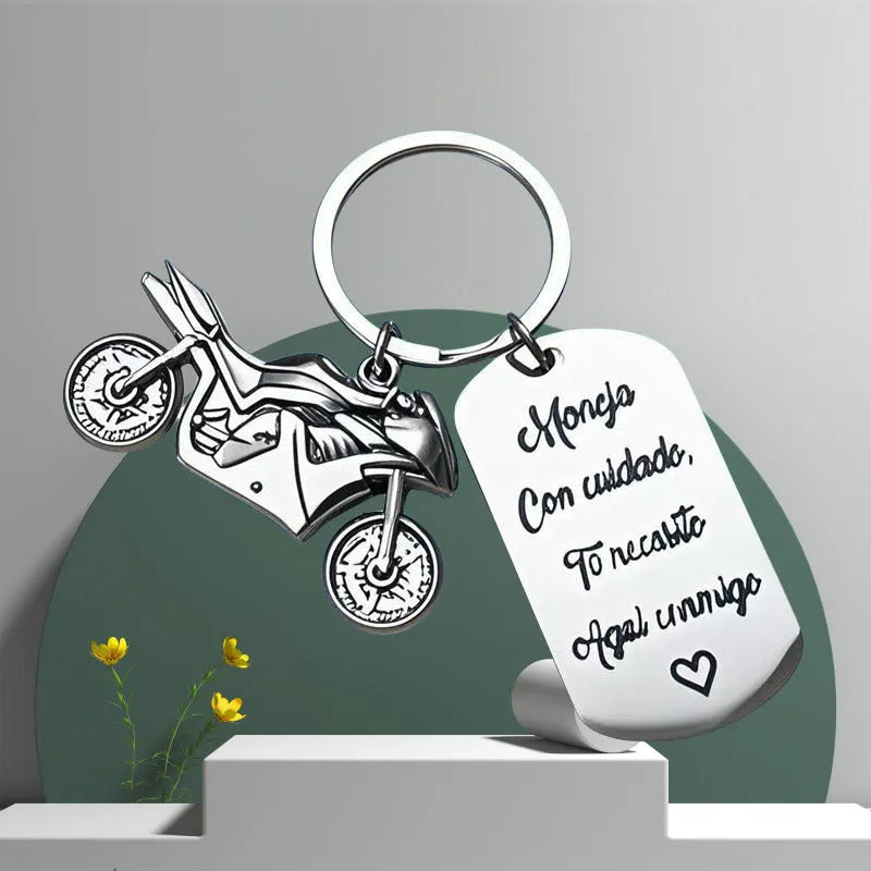 Stainless steel metal keychain on a velvet cloth, showing Motorcycle Keychain and Flannel Bag style options.