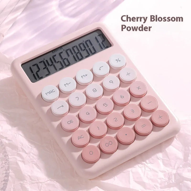 Desktop calculator with a gradient colour design in violet, blue, green, and pink tones on a white desk.