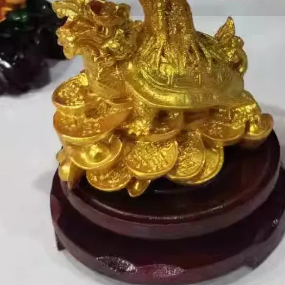Citrine-coloured resin turtle money tree Feng Shui ornament on display.