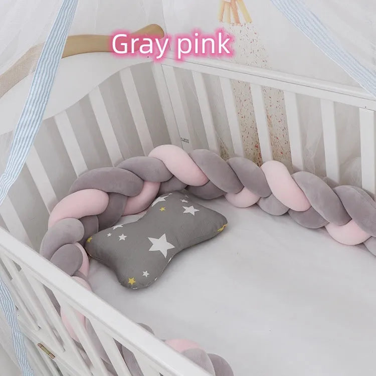 Braided knot baby crib bumper in spandex velvet wrapped around white cot rails.
