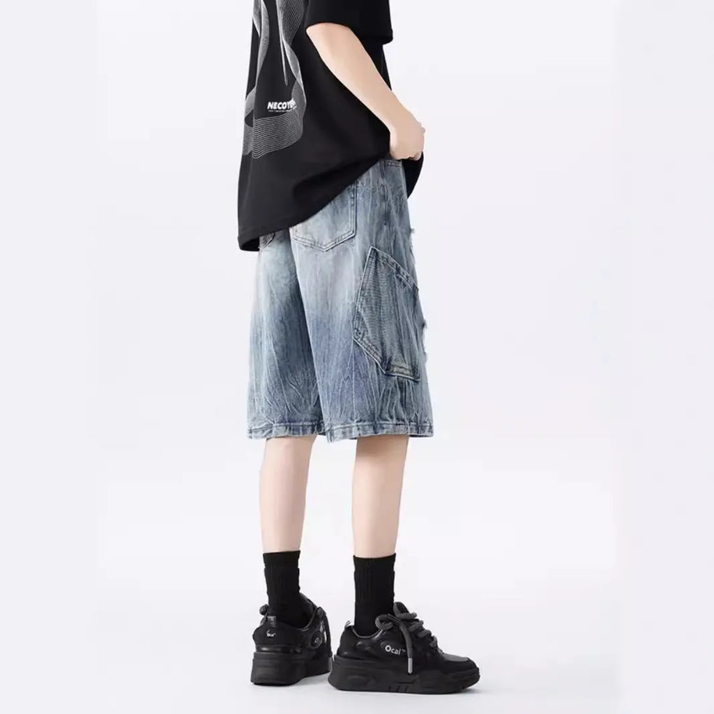 Washed denim shorts with ripped detailing in loose retro style, available in black or blue