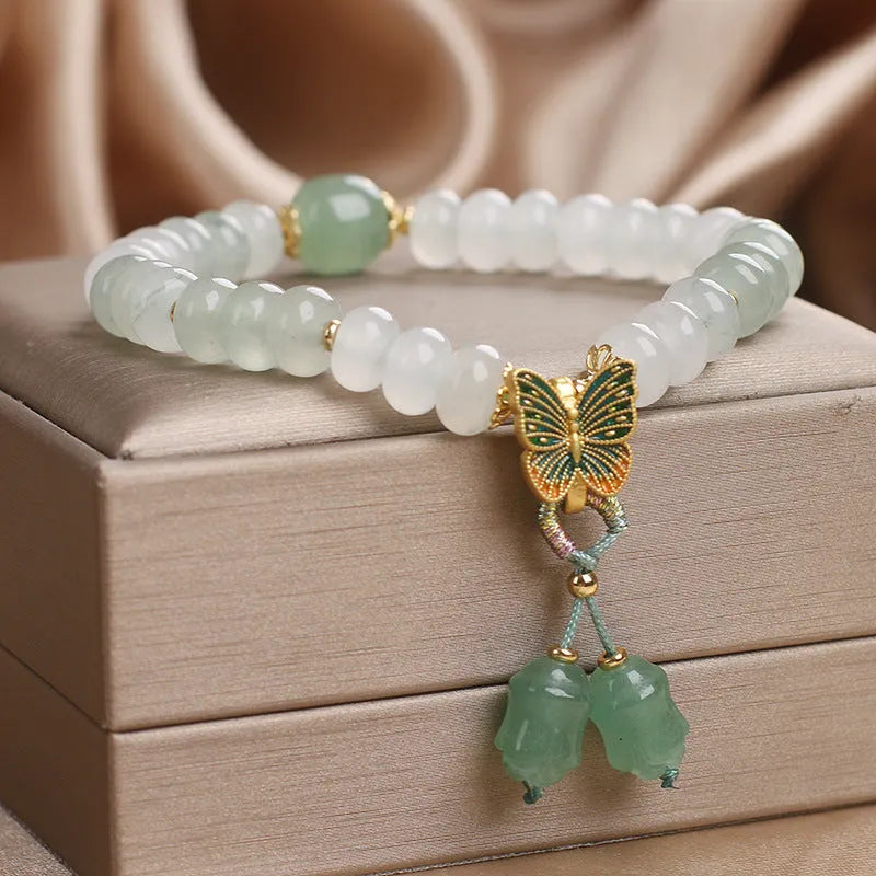 Green crystal Tian Shan Cui abacus bead bracelet with butterfly tassel, pearls and rhinestones.