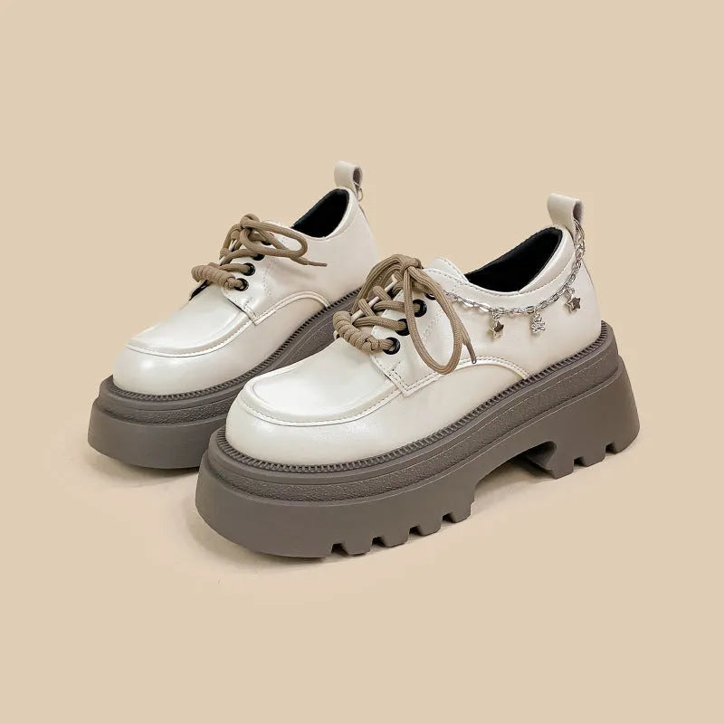White platform Mary Jane shoes with chunky heel and front lace-up detail on a round toe.