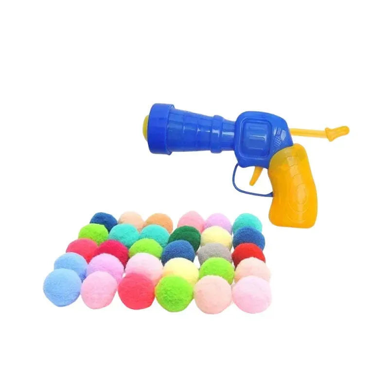 Pet toy launcher gun and soft plush balls for interactive play with cats and dogs.