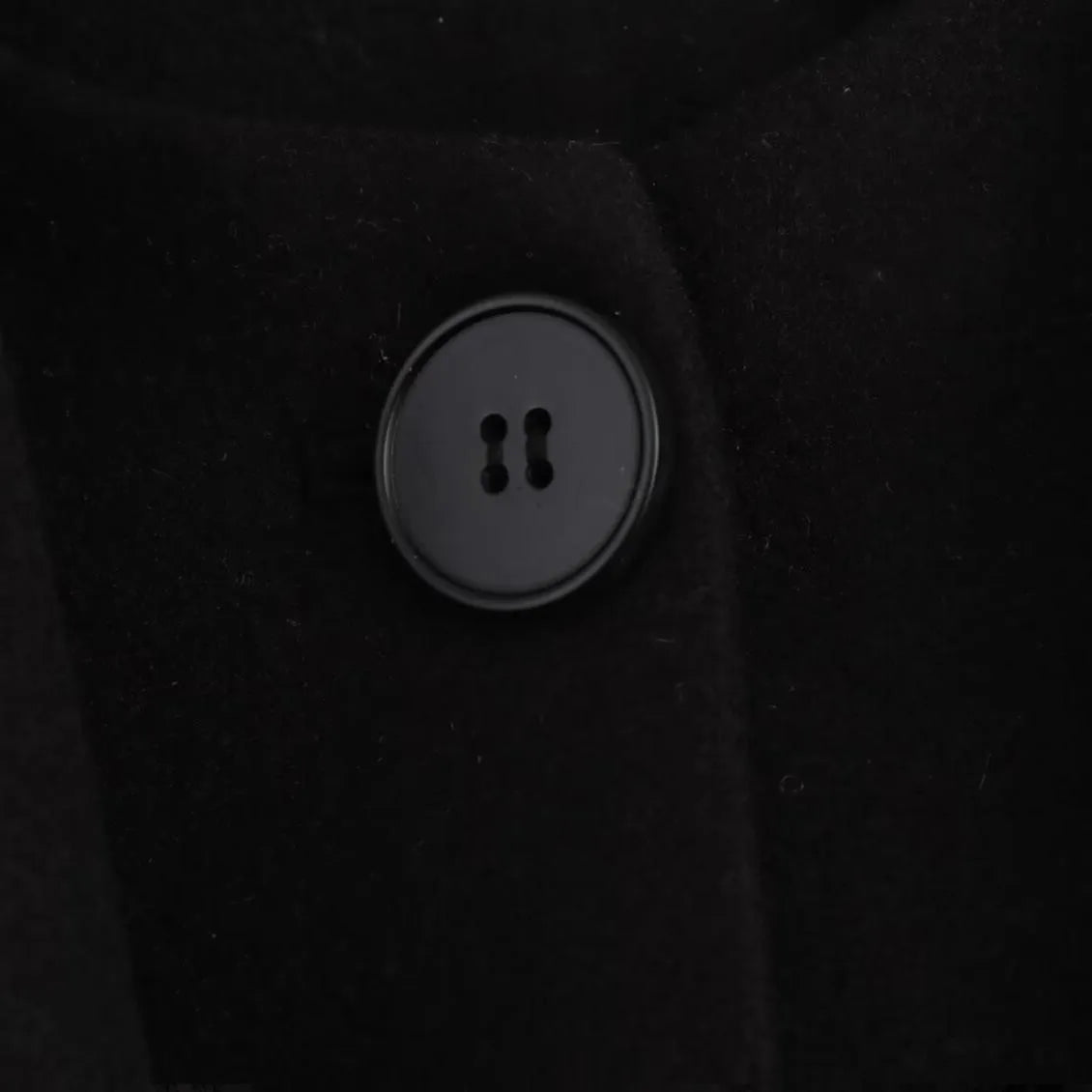 Women's long black polyester coat with a fluffy artificial fur collar, side pockets, and a street-fashion silhouette.