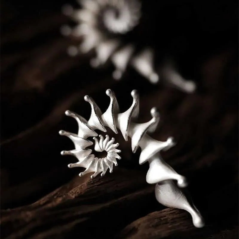Exaggerated three-dimensional matte conch stud earrings in an alloy with an electroplated finish.