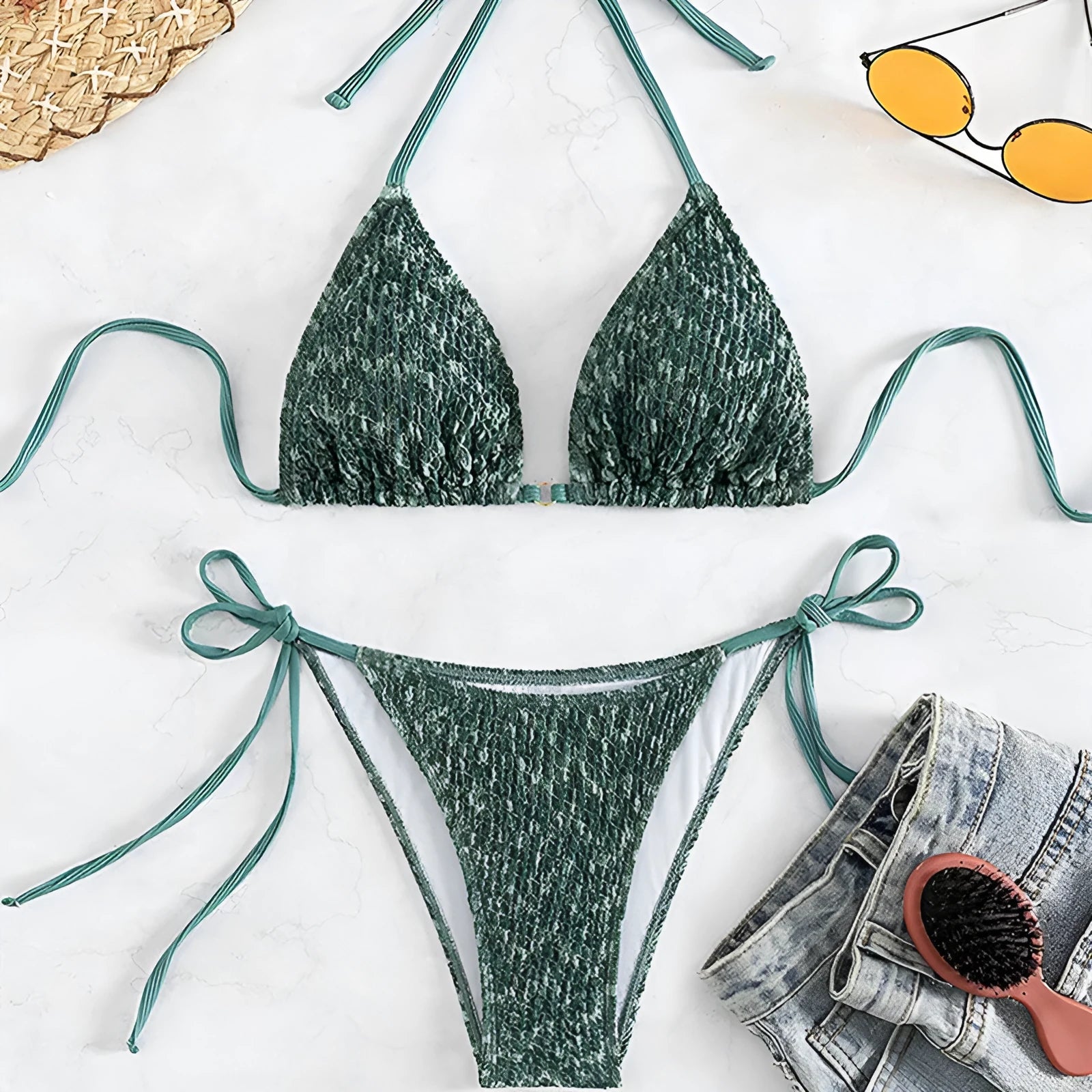 Women's green halter strap backless swimsuit top with matching shorts on hanger