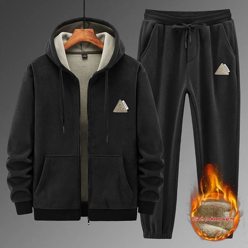 Man wearing a grey hooded zip-up sports jacket and matching trousers from a casual sports suit set.