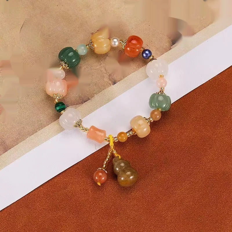 Carved pumpkin and lotus bead bracelet made from Bodhi root with white jade and aventurine details.