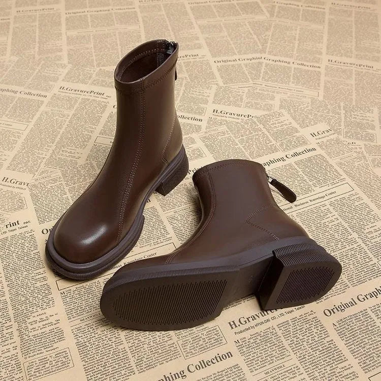 Women's black ankle boot with round toe, thick flat heel, and rear zipper on a rubber sole.