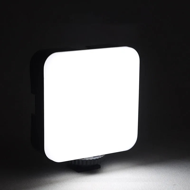 Mini square outdoor camera flash on a small tripod with a rotatable head