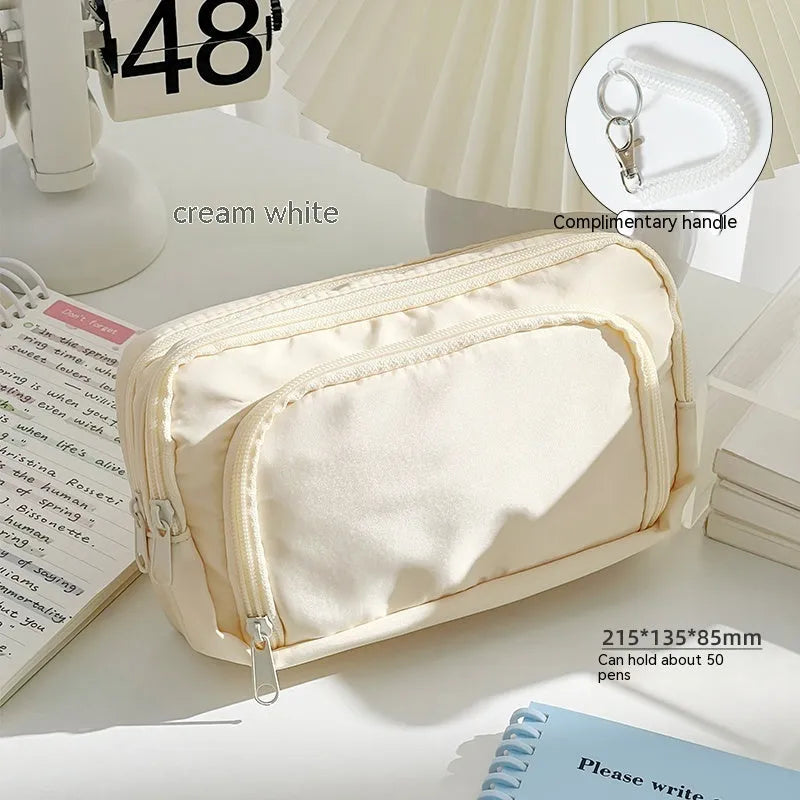 Double-layer pencil case in mint green with gift handle, showing internal divider for stationery organisation