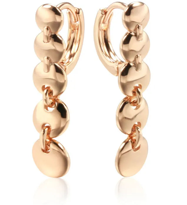 A pair of long, round, gold-toned retro earrings with a woven copper design.