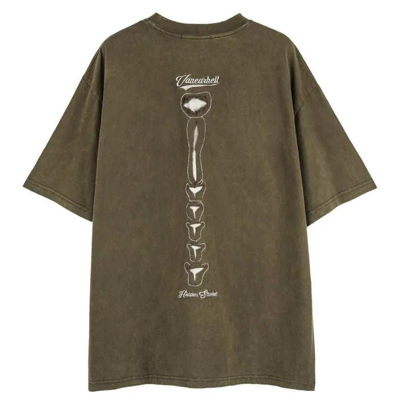 Man wearing a black loose-fit cotton T-shirt with a skull and letter graphic print on the chest.