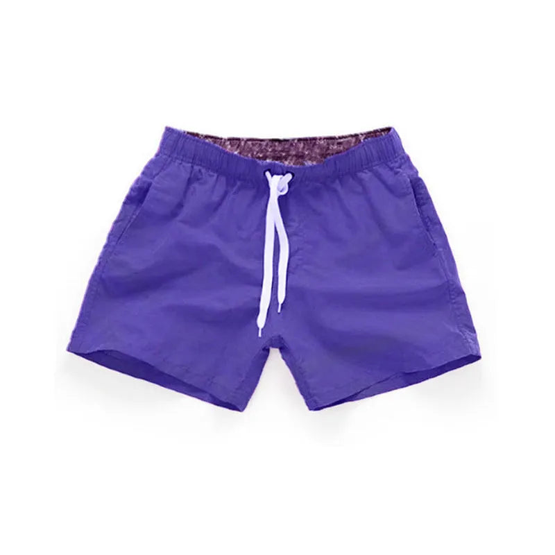 Men's straight-leg beach shorts in polyester, shown in a colour from the range including fluorescent yellow, black, or navy.