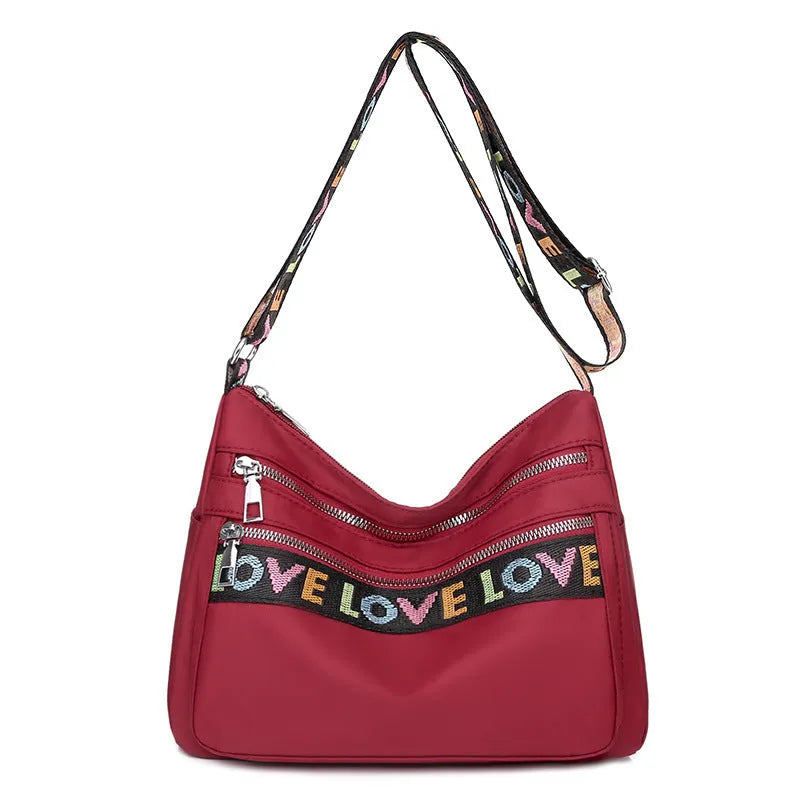 Soft oxford cloth crossbody shoulder bag with multiple pockets, letter stitching, available in black and red