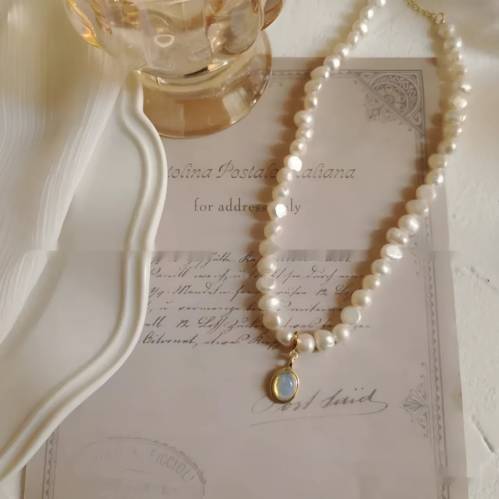 Geometric French Court vintage pearl necklace with adjustable chain on a dark background.