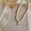 Geometric French Court vintage pearl necklace with adjustable chain on a dark background.