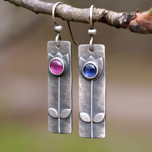 Pair of women's antique finish earrings with red sapphires, geometric shape, and ellipse design on a retro electroplated metal setting.