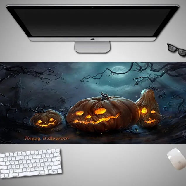 Oversized black Halloween-themed mouse pad with spooky artwork on a desk next to a gaming mouse.