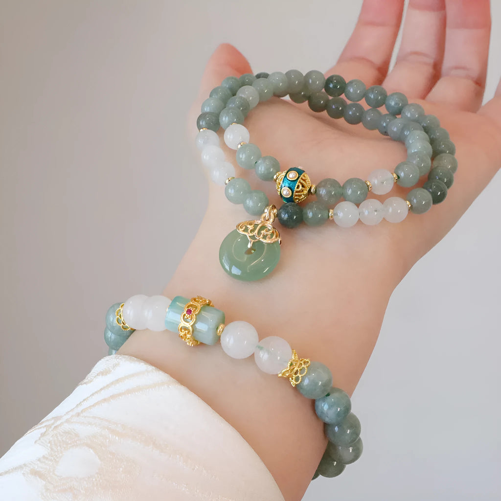 Close-up of a women's Myanmar jade bracelet with a geometric metal safety buckle pendant and lucky beads.