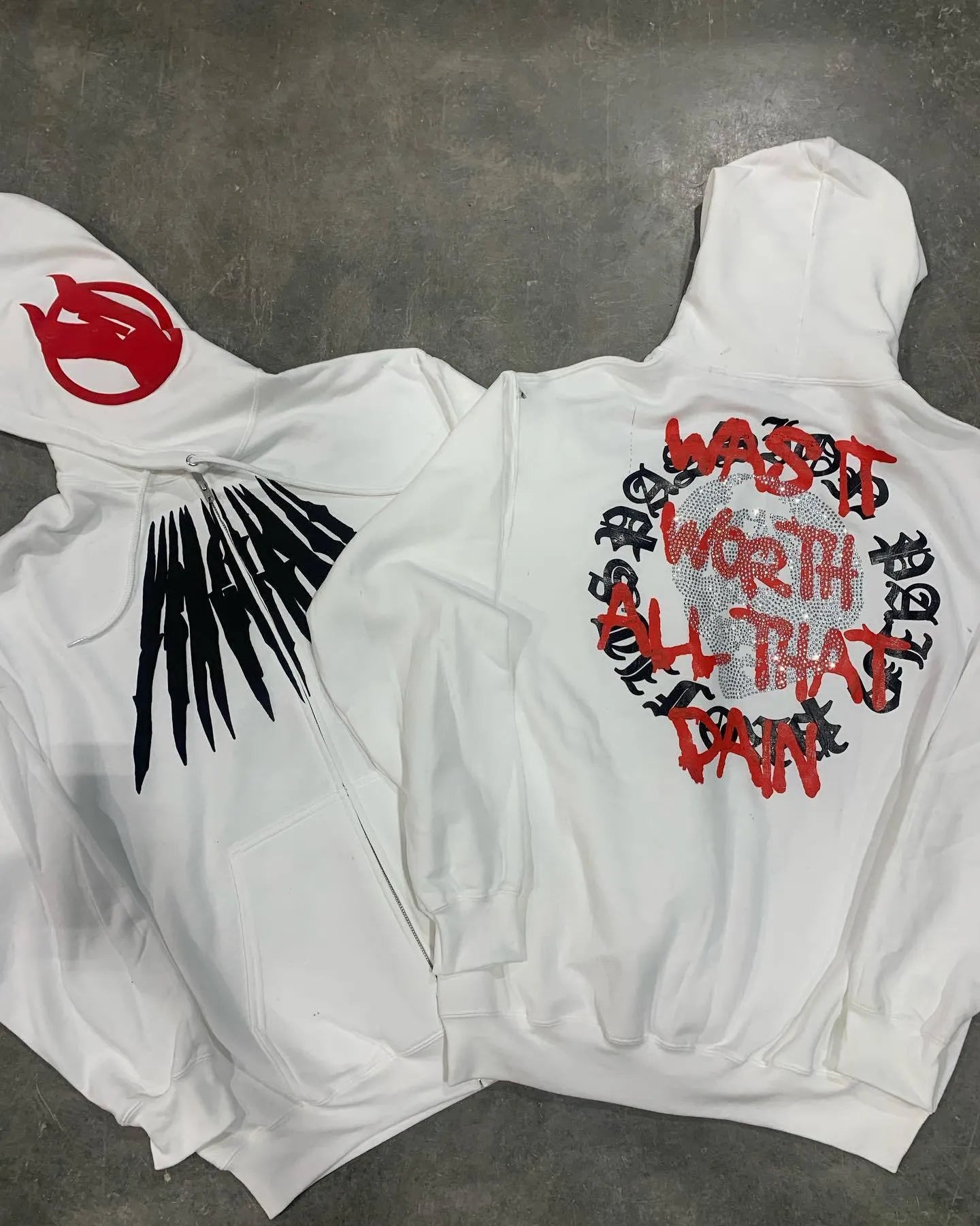 Black loose hooded sweatshirt with white printed skull design and rhinestone details, cardigan style.