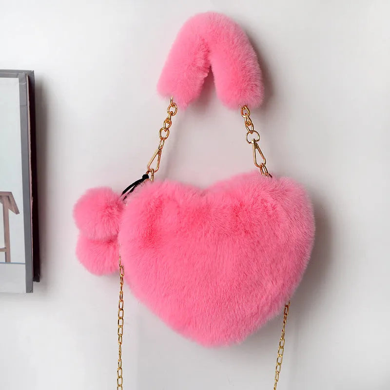 A soft, heart-shaped plush handbag for women in a medium size with a detachable shoulder strap.
