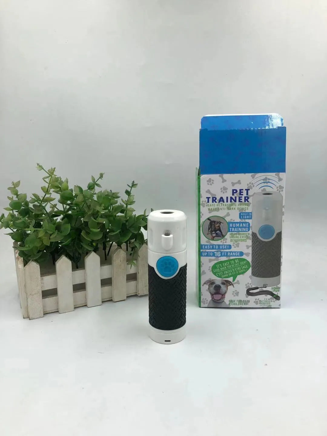 White handheld ultrasonic dog bark control trainer unit on a white background.