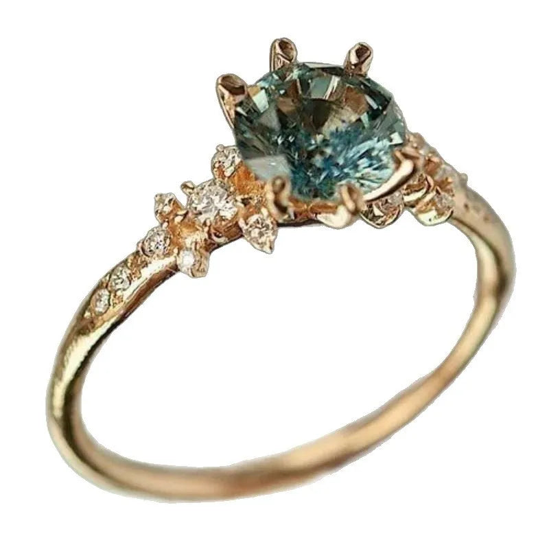 Gold geometric ring with a square chamfered pattern and claw-set zircon stones.