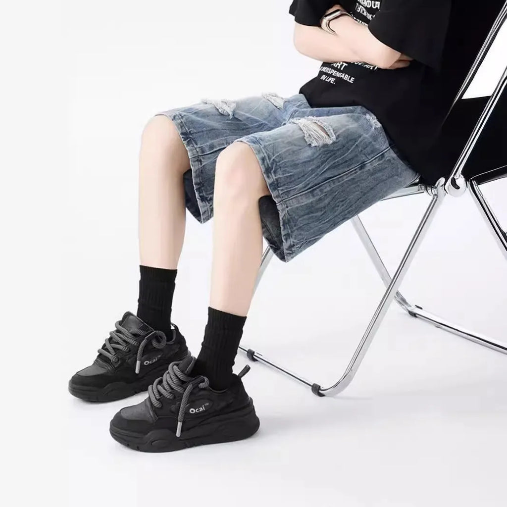 Washed denim shorts with ripped detailing in loose retro style, available in black or blue