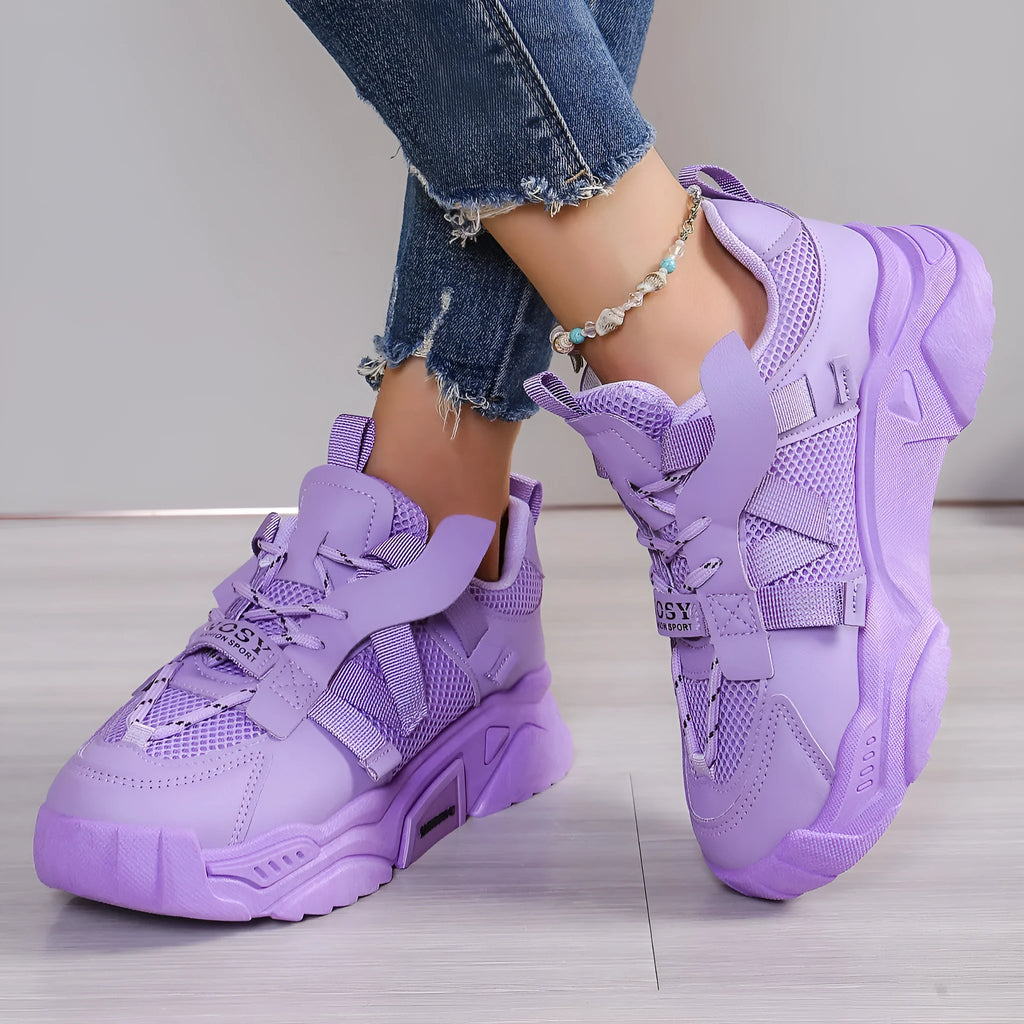 Women's purple platform sneaker with breathable mesh upper and lace-up front on a neutral background.