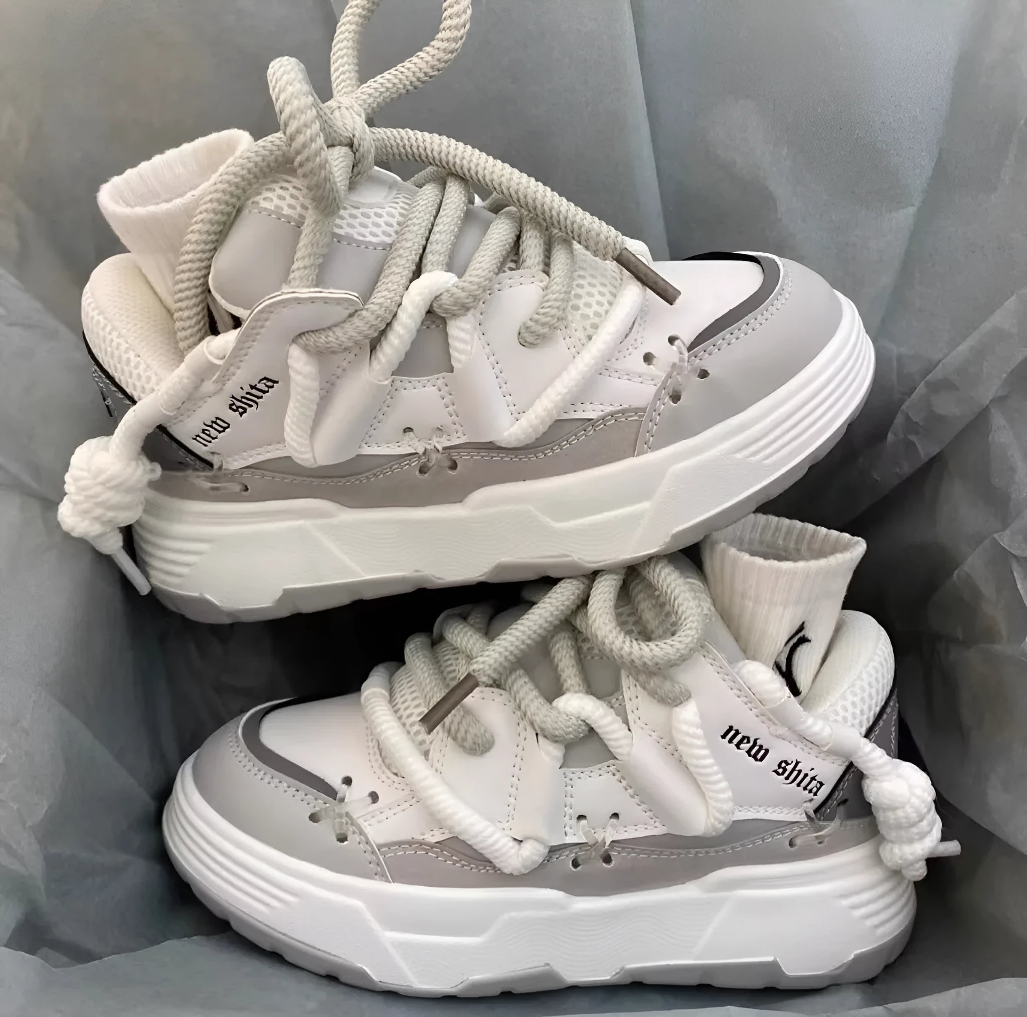 Grey retro clunky sneakers with thick rubber sole and lace-up front, shown on a white background.