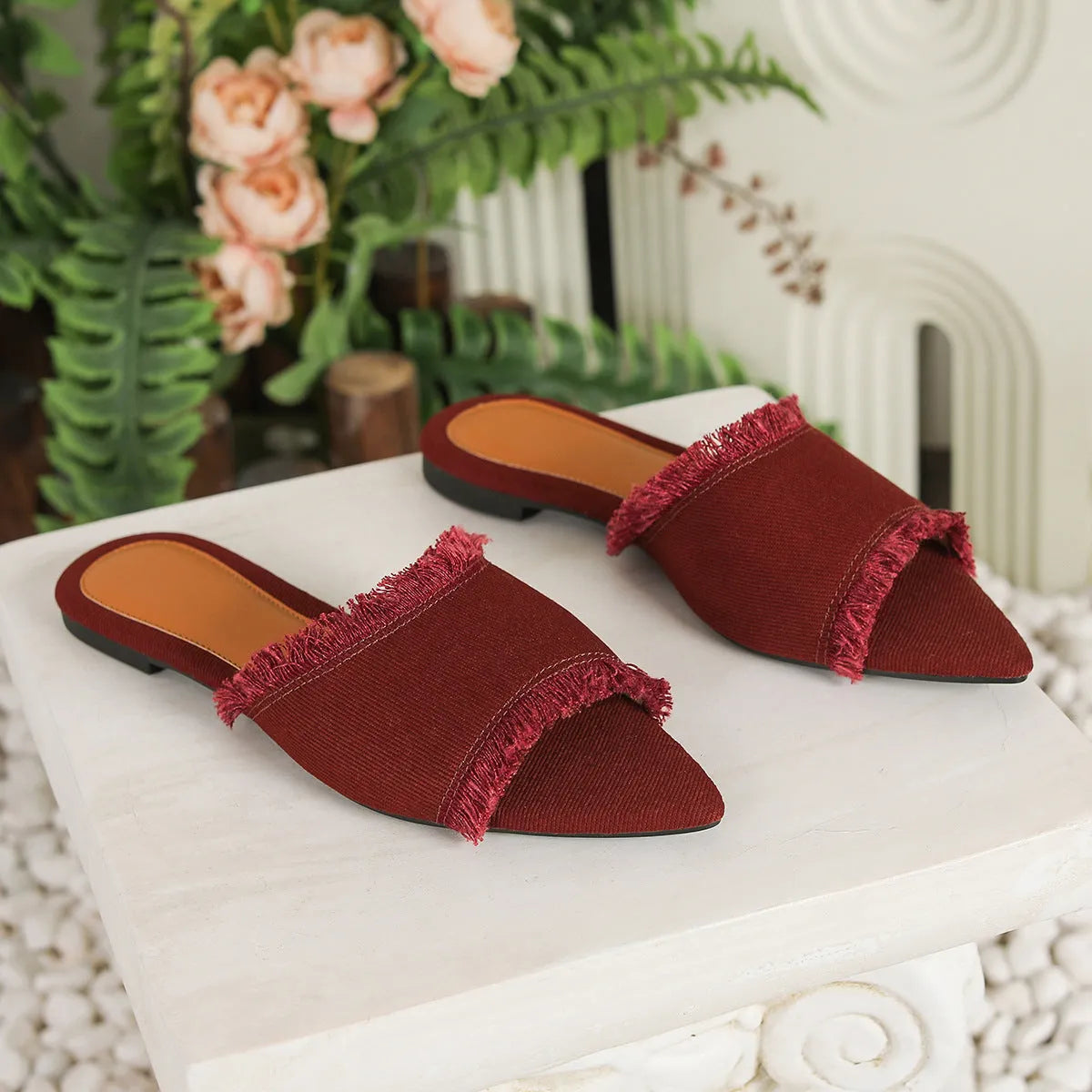 Solid colour denim women's slippers with a tassel detail, showing leather lining and PVC sole.