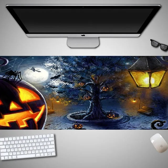 Oversized black Halloween-themed mouse pad with spooky artwork on a desk next to a gaming mouse.