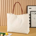 Large natural cotton canvas tote bag with wide straps, shown in beige white colour.