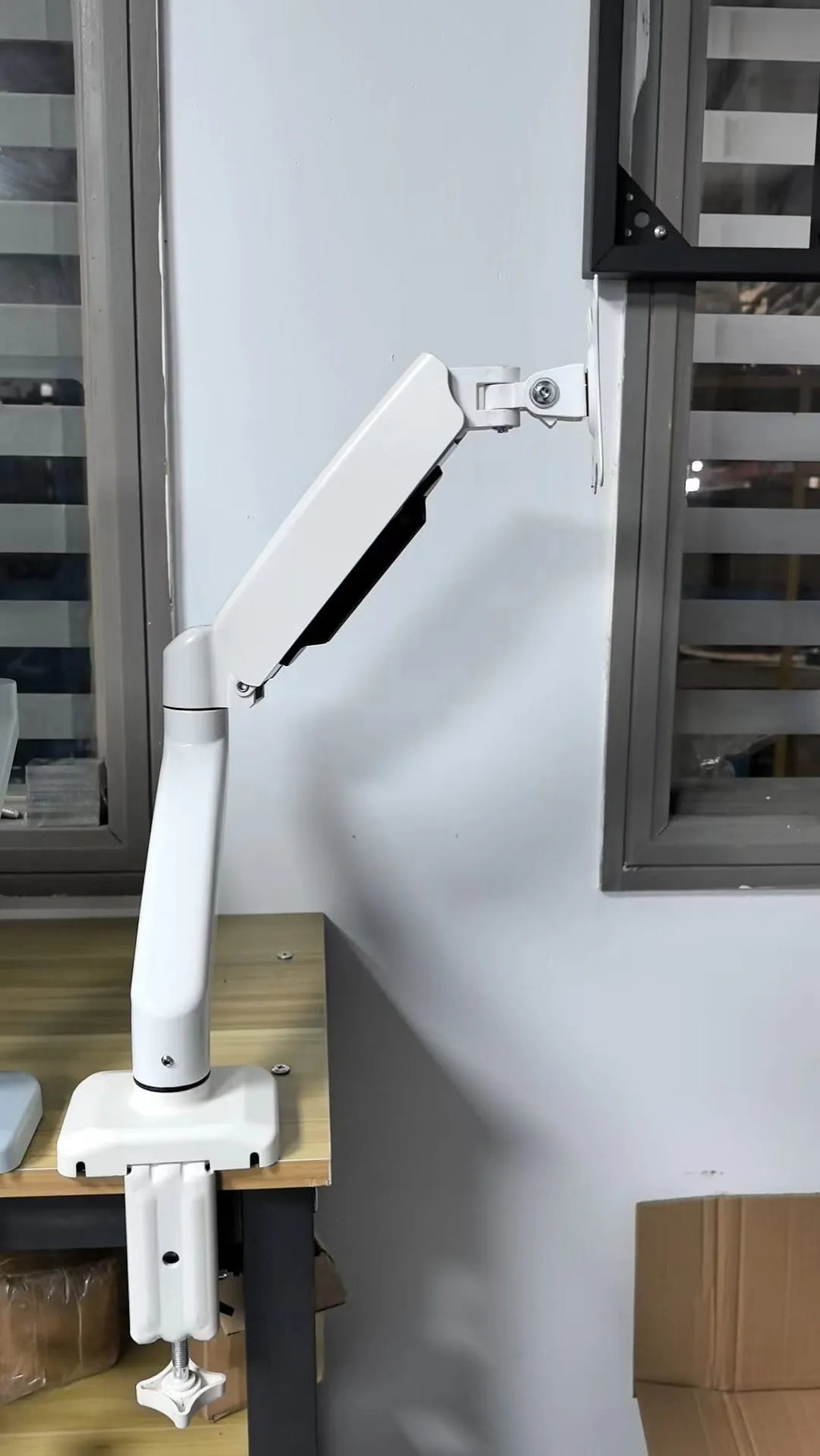 Black rotating telescopic LCD screen bracket on table with adjustable height and rotation features