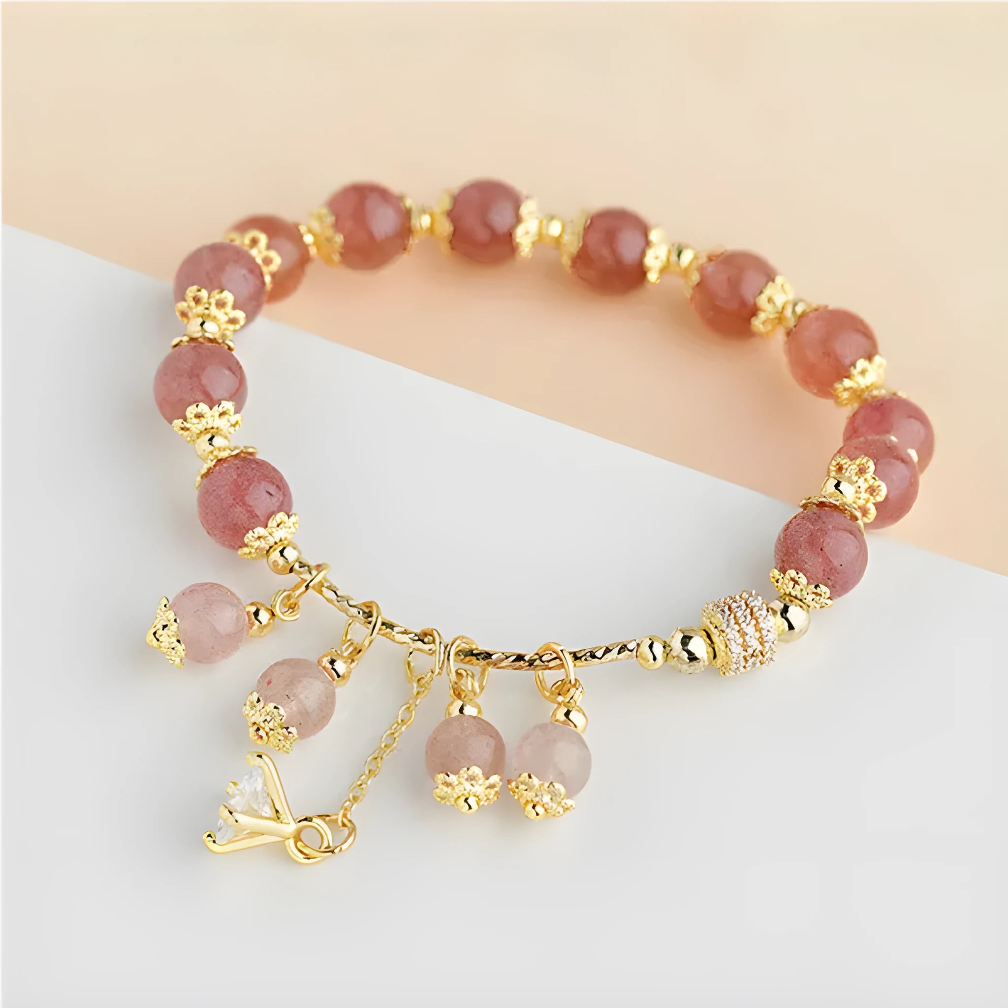 Pink women's bracelet with heart-shaped strawberry quartz crystal beads and freshwater pearl accents on a wrist.