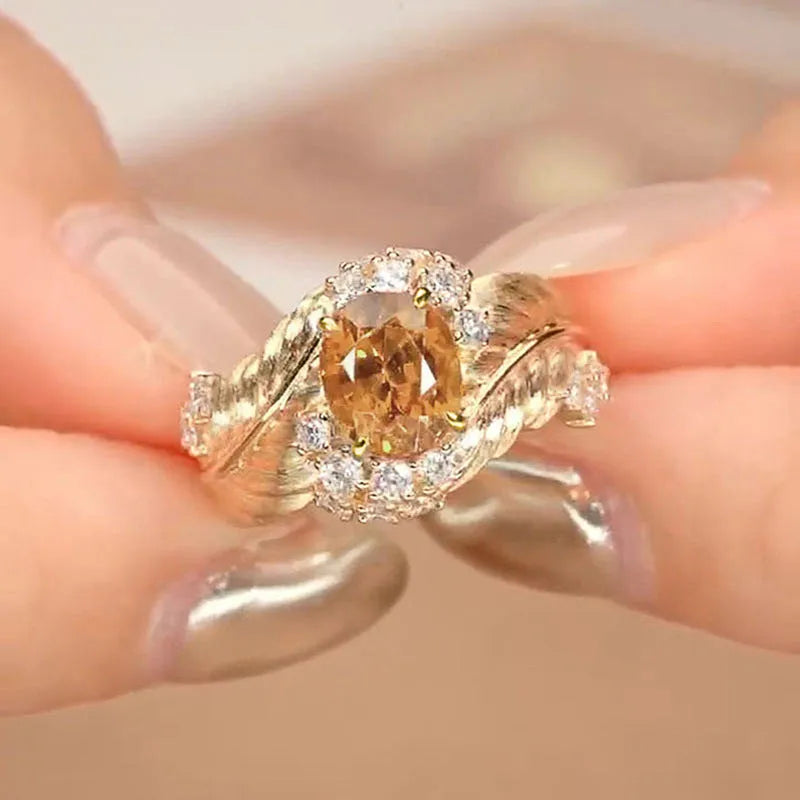 Gold-coloured embossed feather ring for women with an inlaid yellow zircon stone.