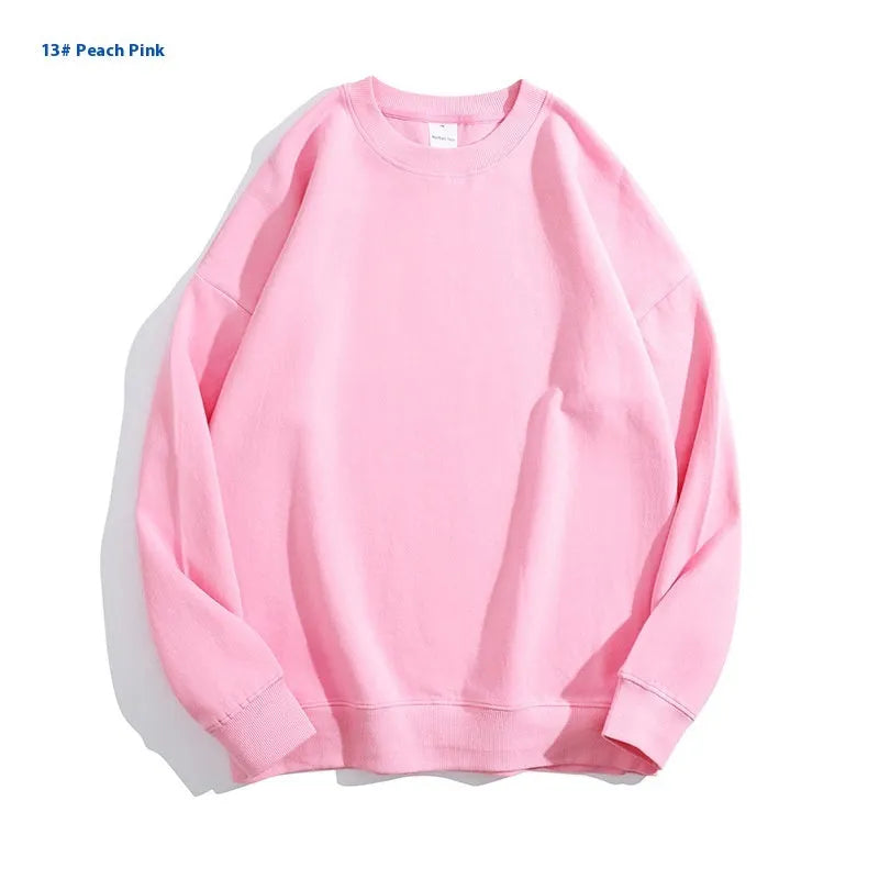 A loose-fitting, off-shoulder cotton sweater in a solid colour with long sleeves and a round neck.
