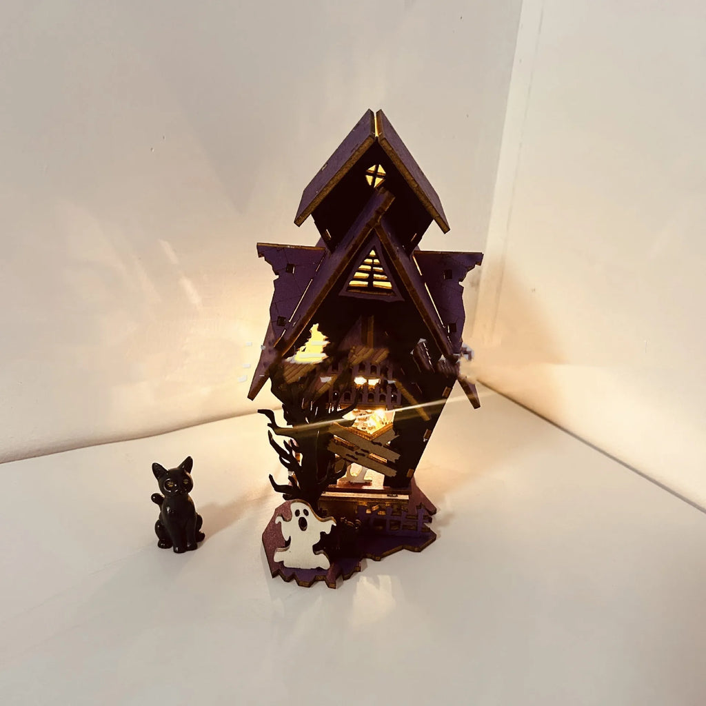 Wooden glowing haunted house Halloween table decoration on a dark surface