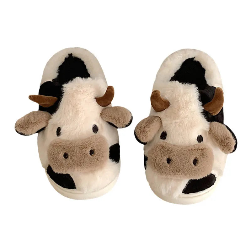 White cartoon cow plush house slippers for women with a non-slip textured sole.
