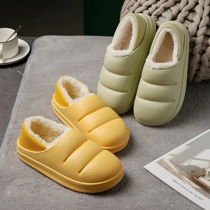 Green waterproof EVA garden slippers with plush lining and a non-slip sole, shown on a wooden deck.