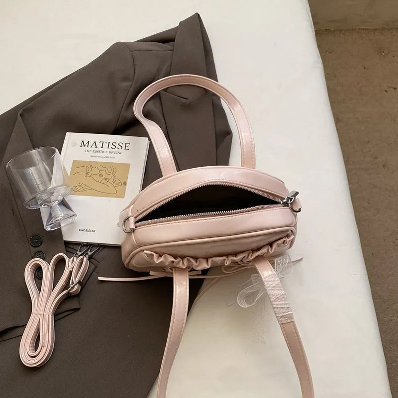Women's casual bandage bow handbag in PU with shoulder strap and sewing thread detailing.