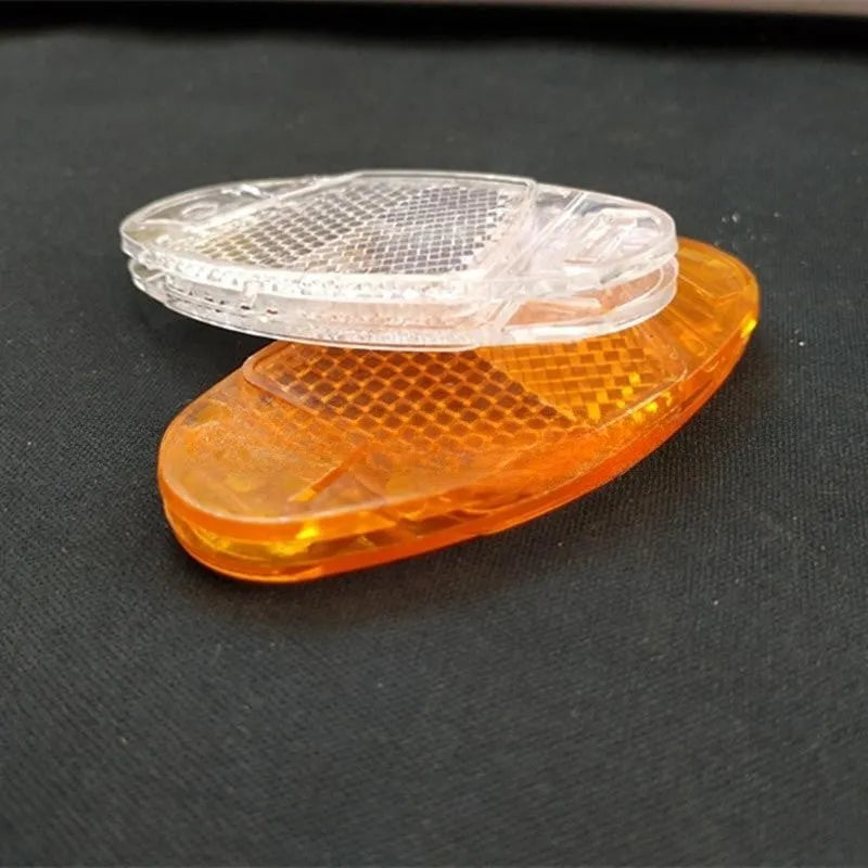 Bicycle spoke reflector showing yellow plastic construction with clip-on attachment for wheel safety